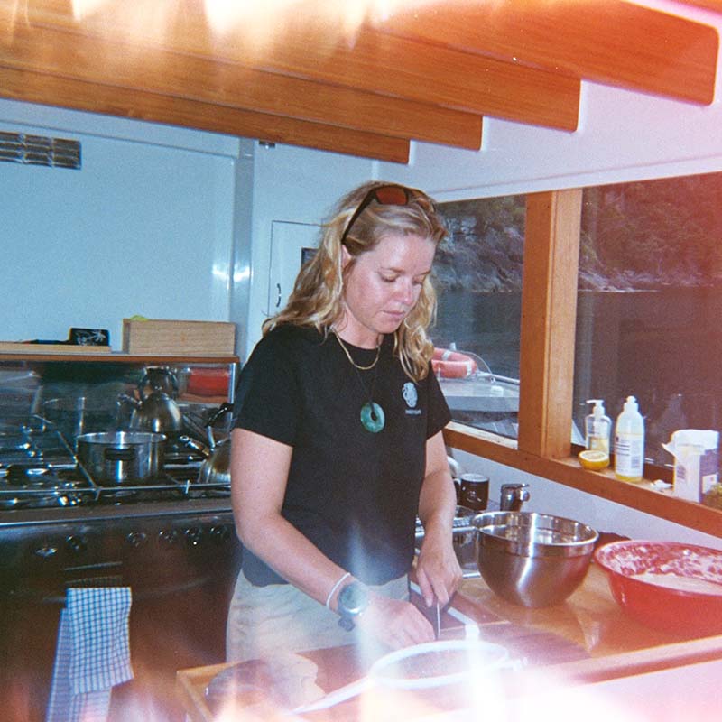 Ingrid in a boat kitchen preparing food.