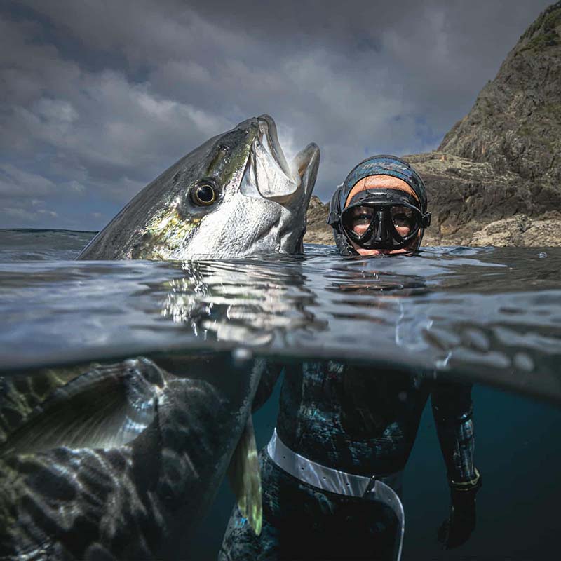Lorelei in wetsuit and snorkel with a large fish underwater