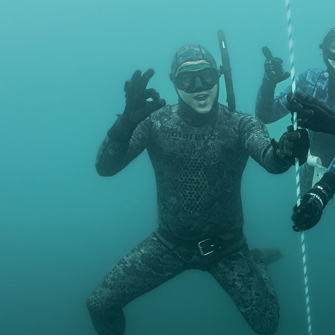 Sam in a wetsuit and freediving gear underwater